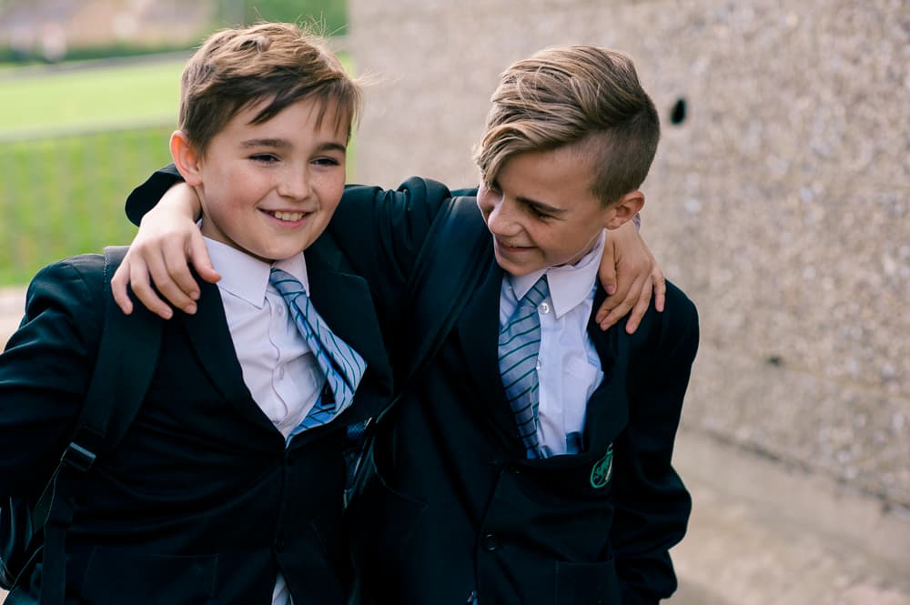 Two boys at school with there arms around each other